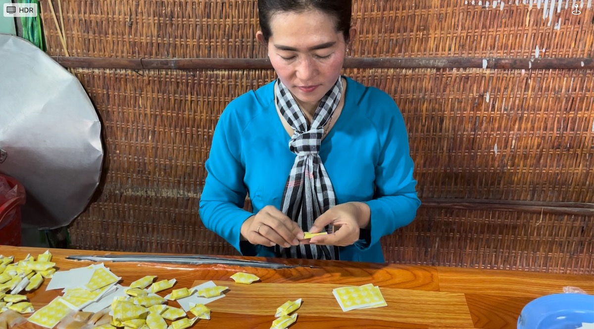 Donna che confeziona a mano le caramelle al cocco