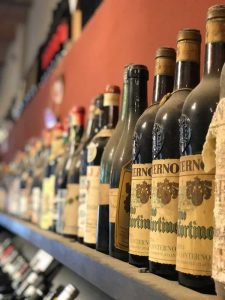Le Langhe in auto: Bottiglie di vino in una cantina