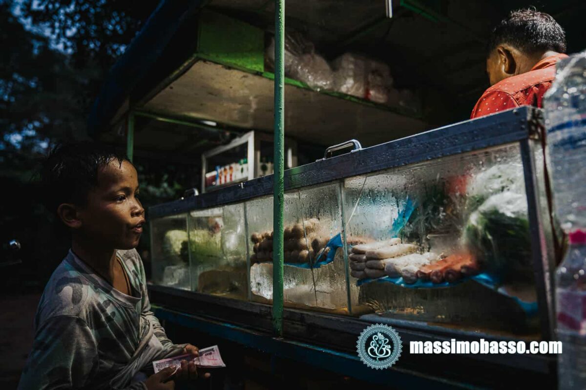 Ragazzino che compra cibo in una bancarella - Siem Reap - Cambogia